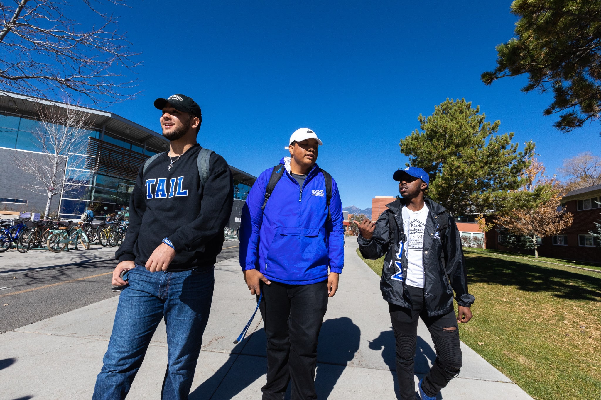 Three students walk together on campus.