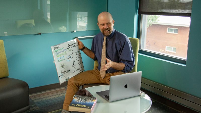 Instructor shows whiteboard to class virtually via laptop.