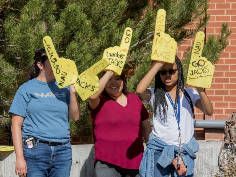 Students hold Kiss My Axe prop at homecoming parade.