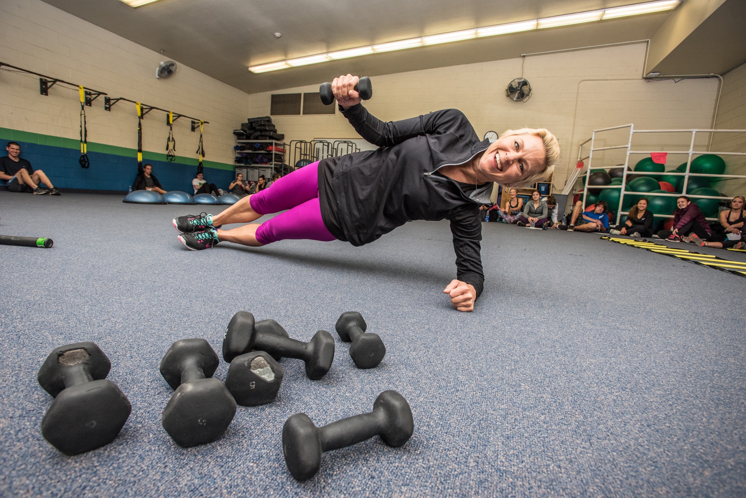 Student does a side plank in workout room.
