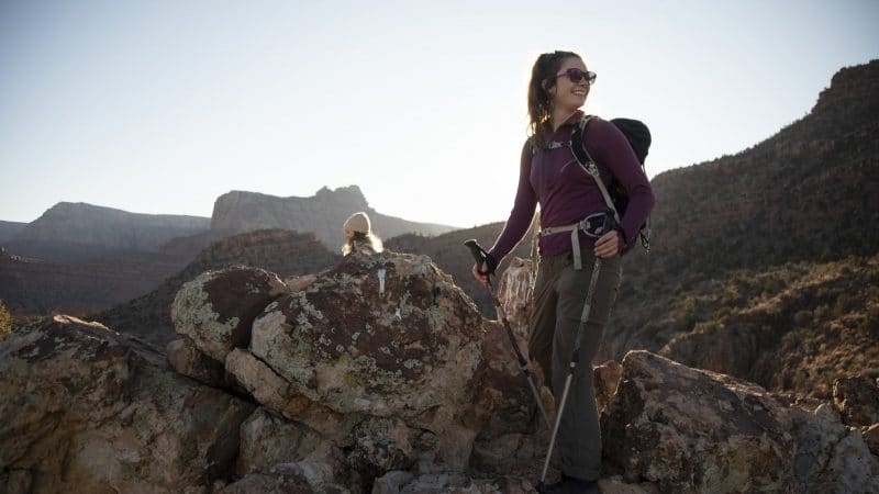 Student hiking on large rocks.