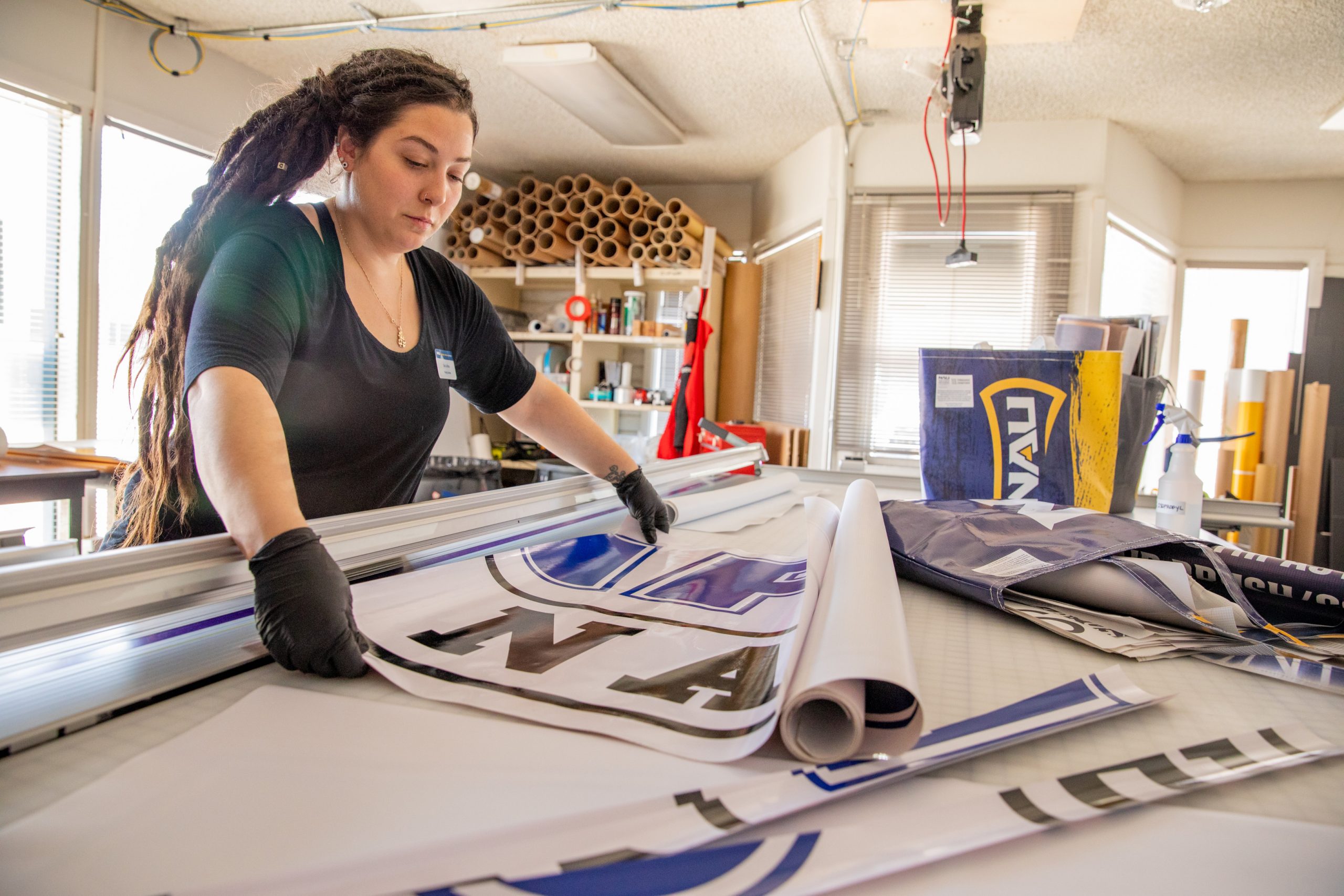 NAU alumni Sara LaRosa trimming NAU posters.