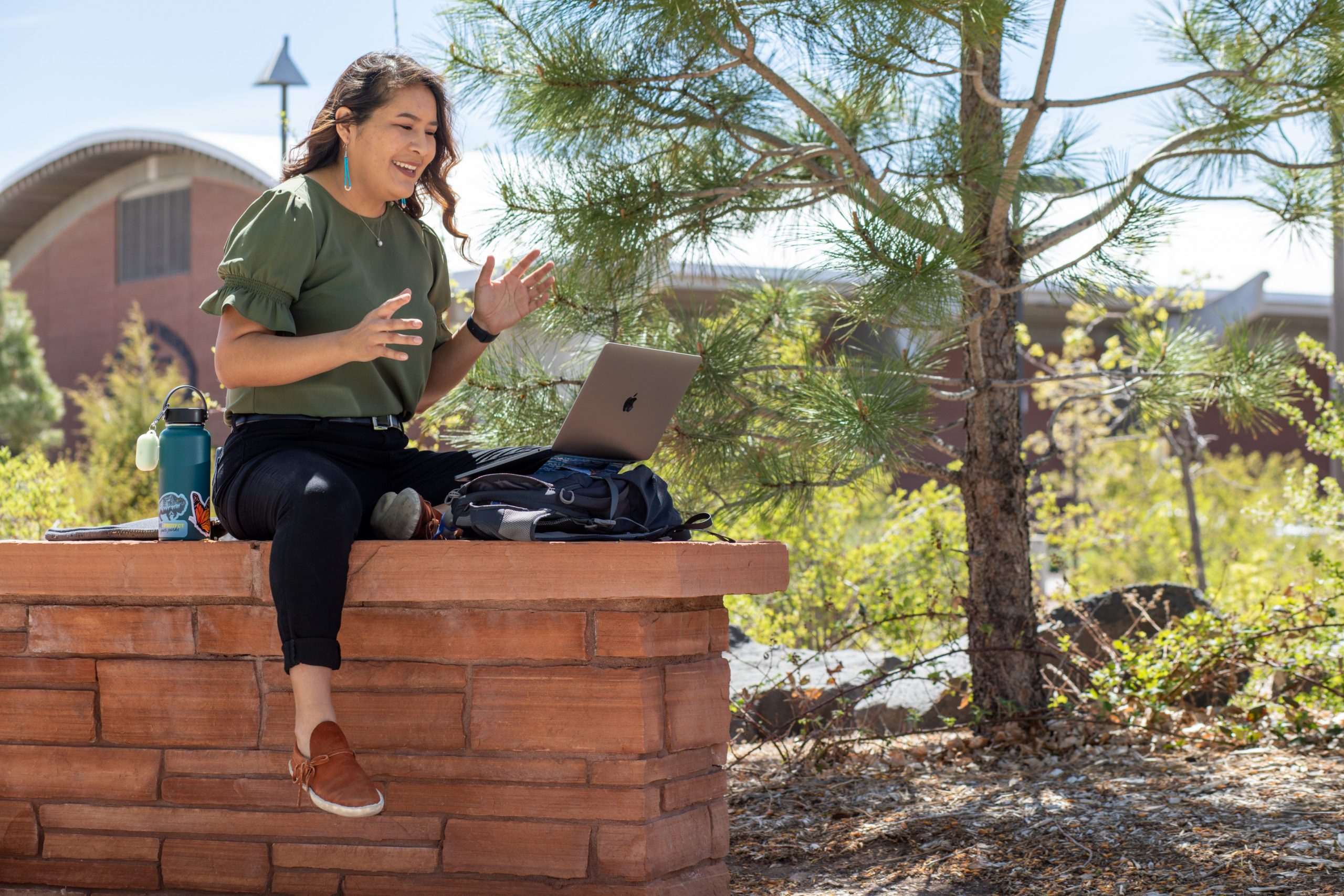Jayne Sandoval working on her laptop outside.