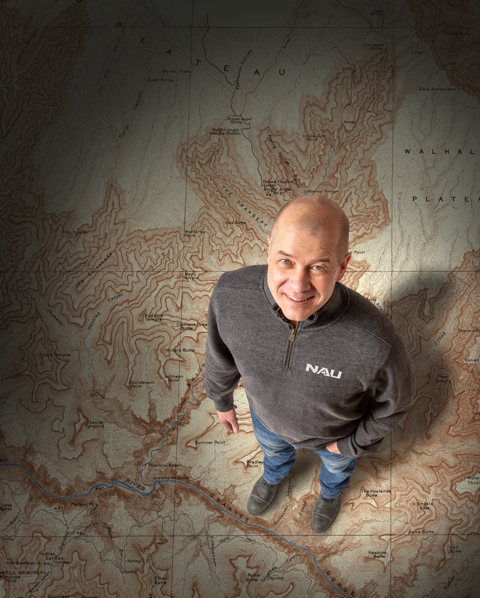Dave Cook standing on a large map.