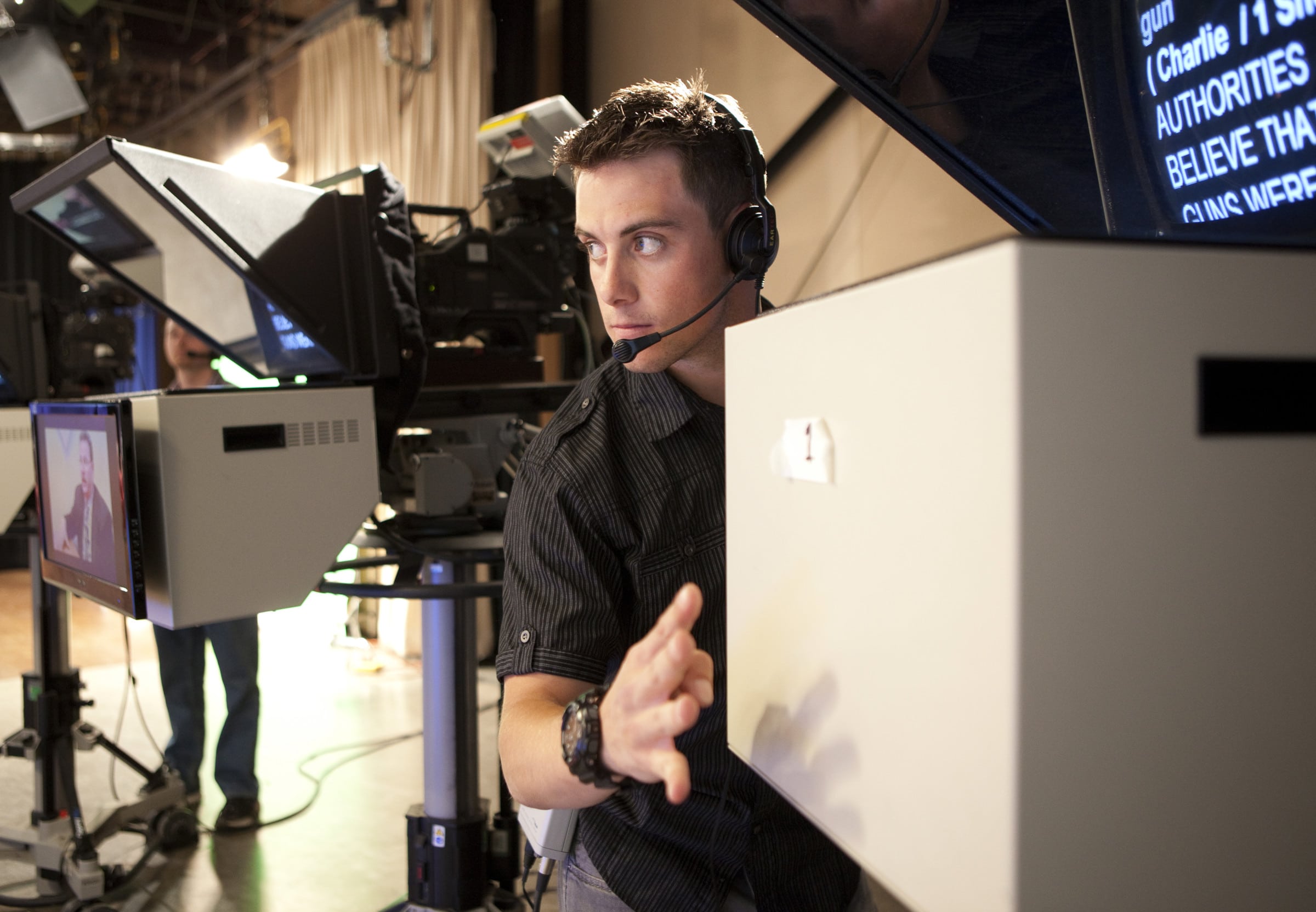NAU communications student wearing headphones on set.