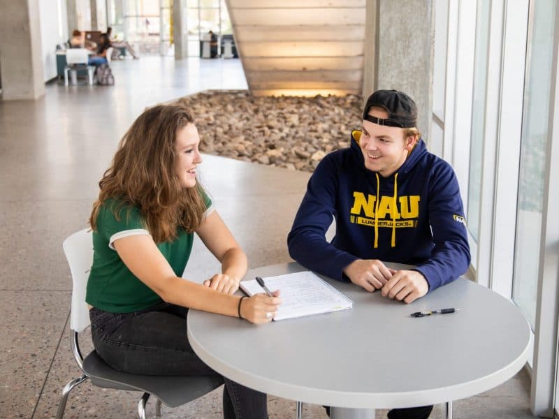 Students smiling and working together in health science building.