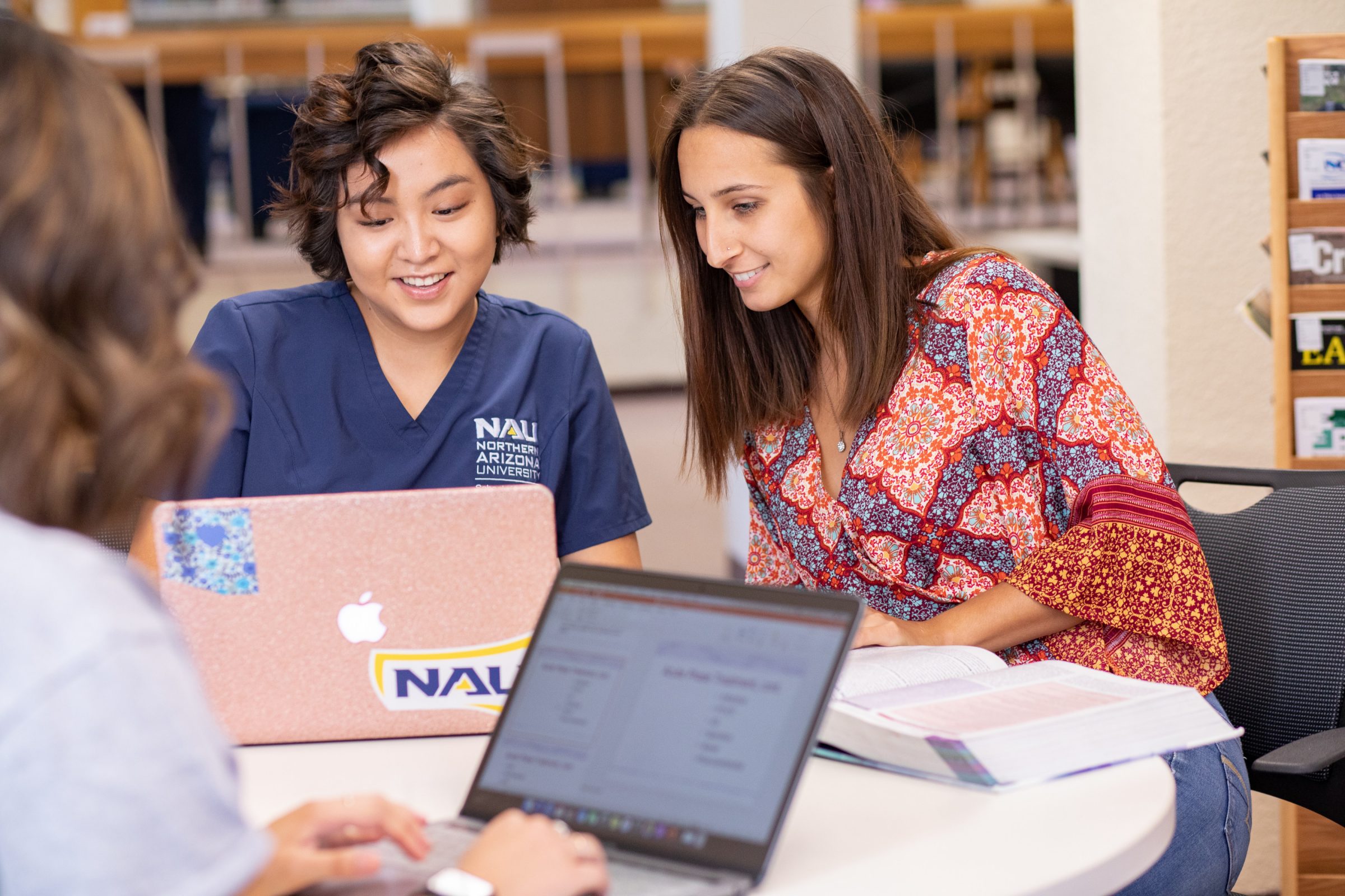 Students work together on their laptops at the N A U-Yuma library.