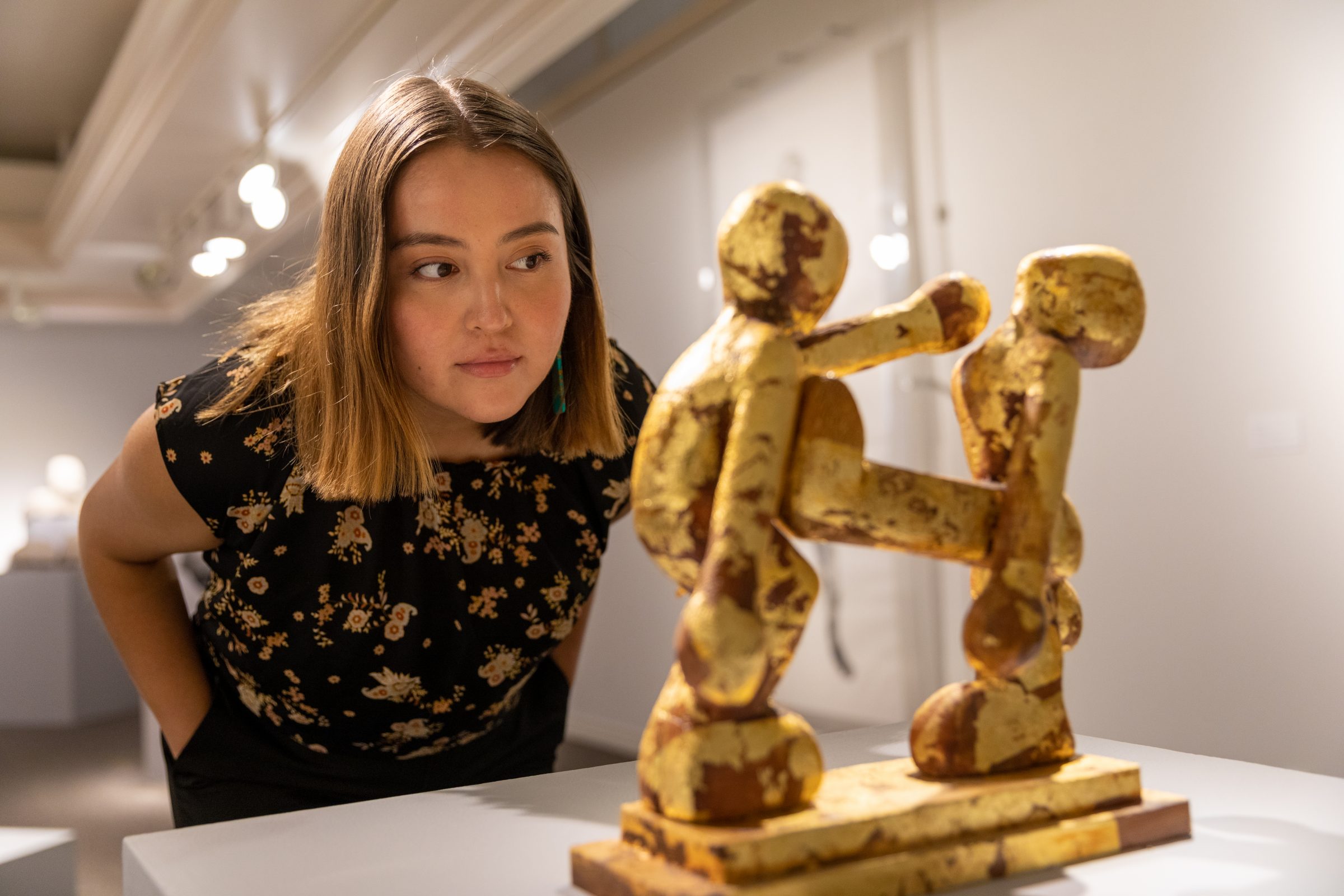 N A U student Autumn Begay looks at a native sculpture.