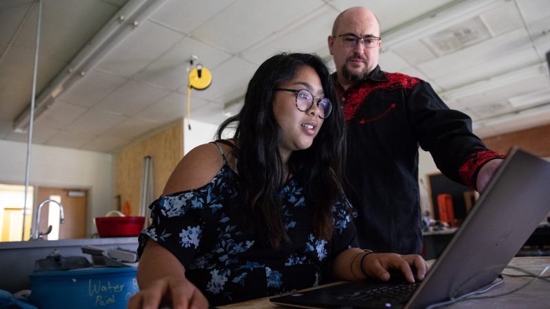 David Winslow Van Ness oversees a student working on a laptop.