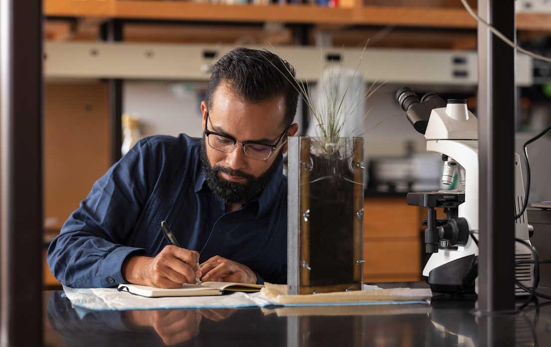 N A U faculty member writing in a journal in a lab.