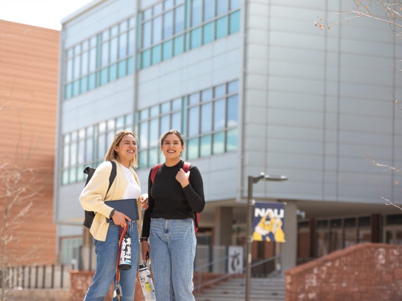 Student's smiling while outside on campus.
