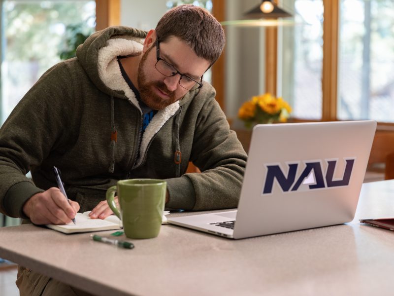 N A U student working on their laptop.