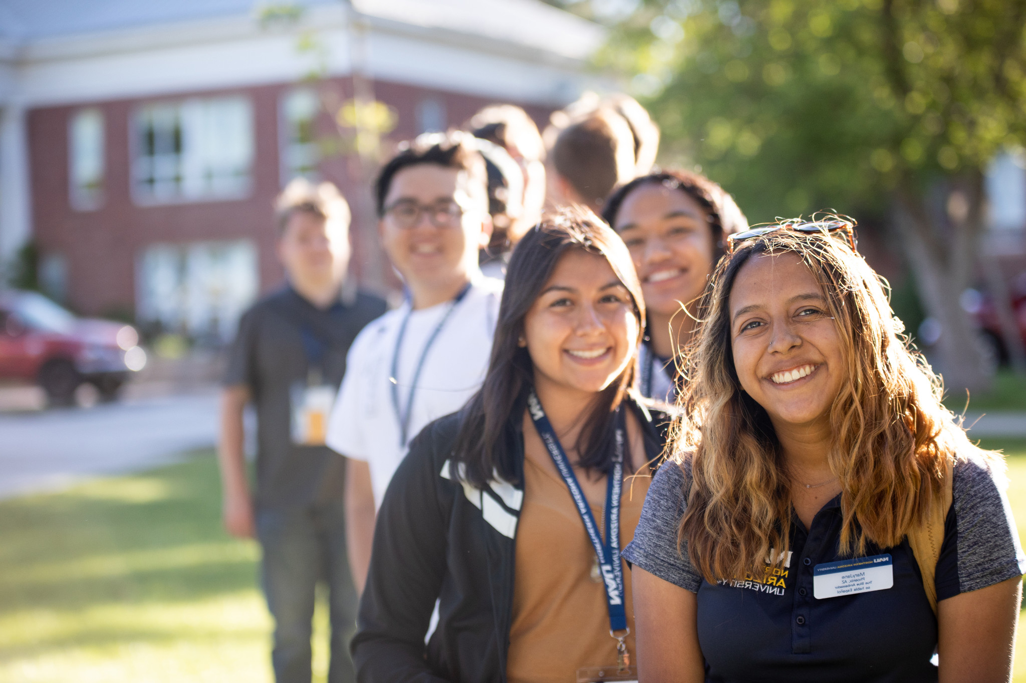 Students line up and smile at N A U.