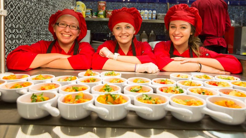 Chefs pose with their food before it's served.