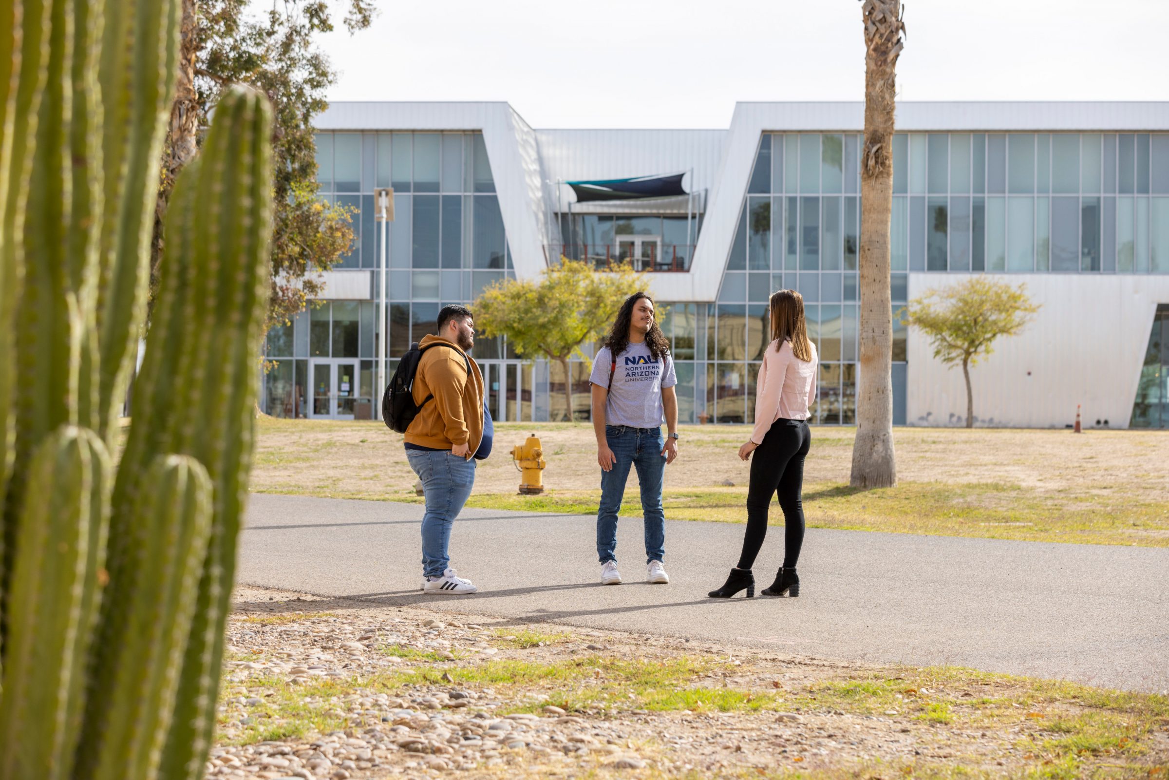 Three students talking outside N A U Yuma campus.