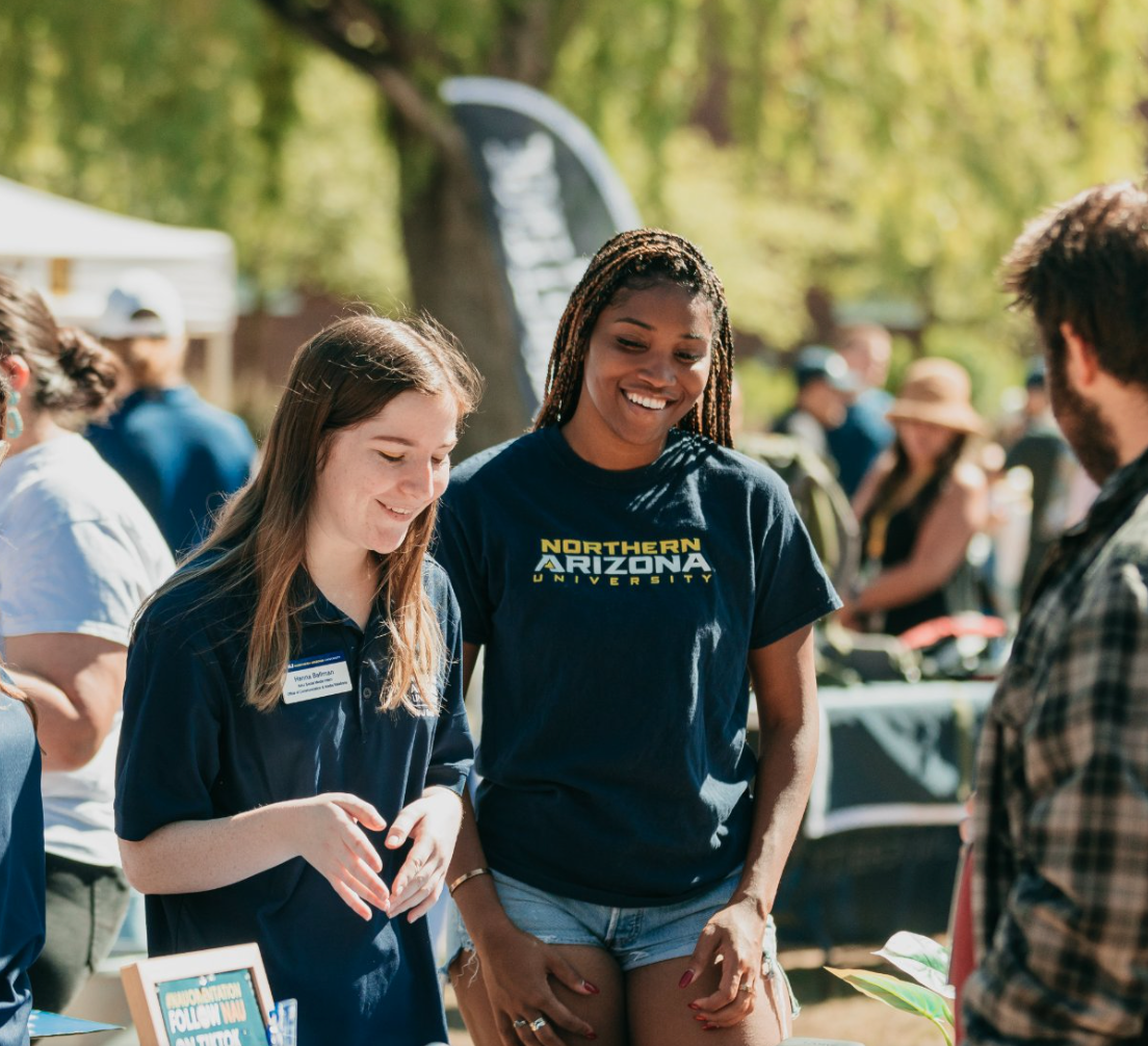 Student's smiling with speaking to someone on a booth.