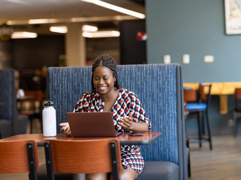 An N A U Online graduate student attending class online from a coffee shop.