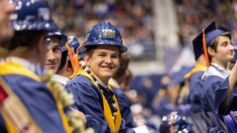An N A U engineering student smiles happily at commencement.