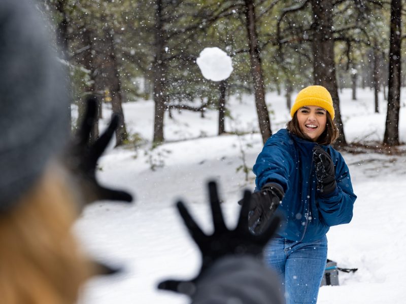 NAU students have a snowball fight on campus.