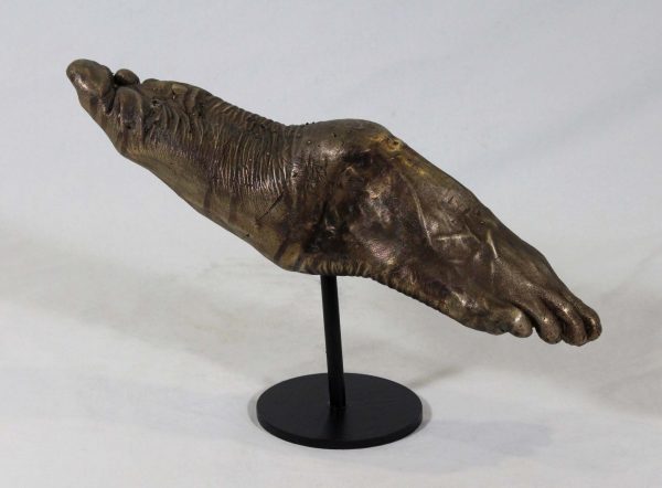 Sculpture of bronze human feet in a see saw formation.