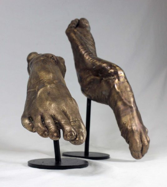 Sculptures of human feet in a see saw formation.