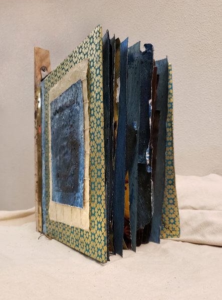 A mixed media book standing.