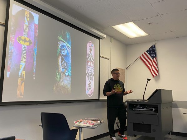 Duane Koyawena stands in front of a projector of his art