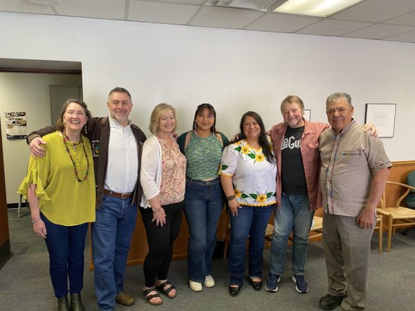 CCS faculty stand against a wall with Luis Urrea.