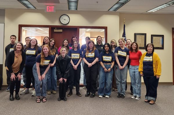 A group of students stand in a classroom.