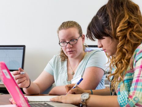 Two girls looking at a laptop screen