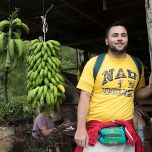 NAU student next to a fruit plant