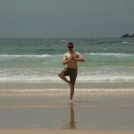 NAU student doing a yoga pose at the beach.