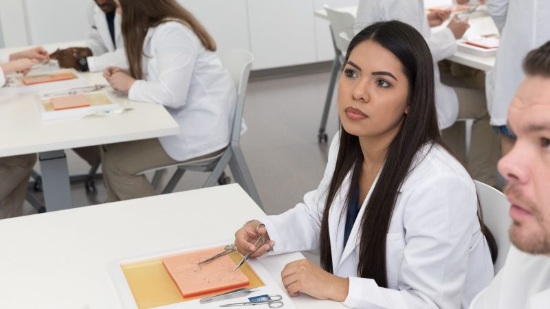 Student in white lab coat.