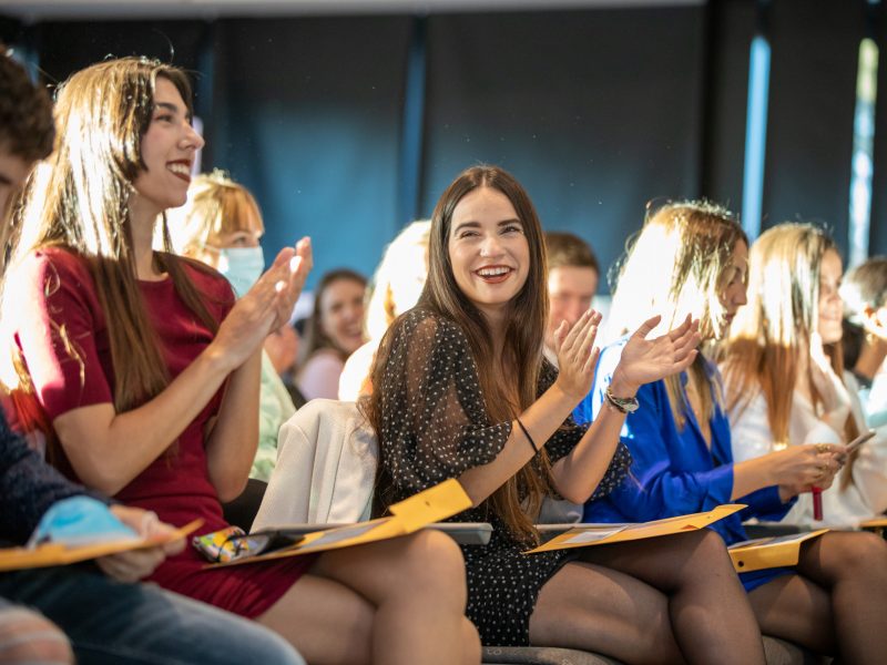 An audience of people clapping and smiling.