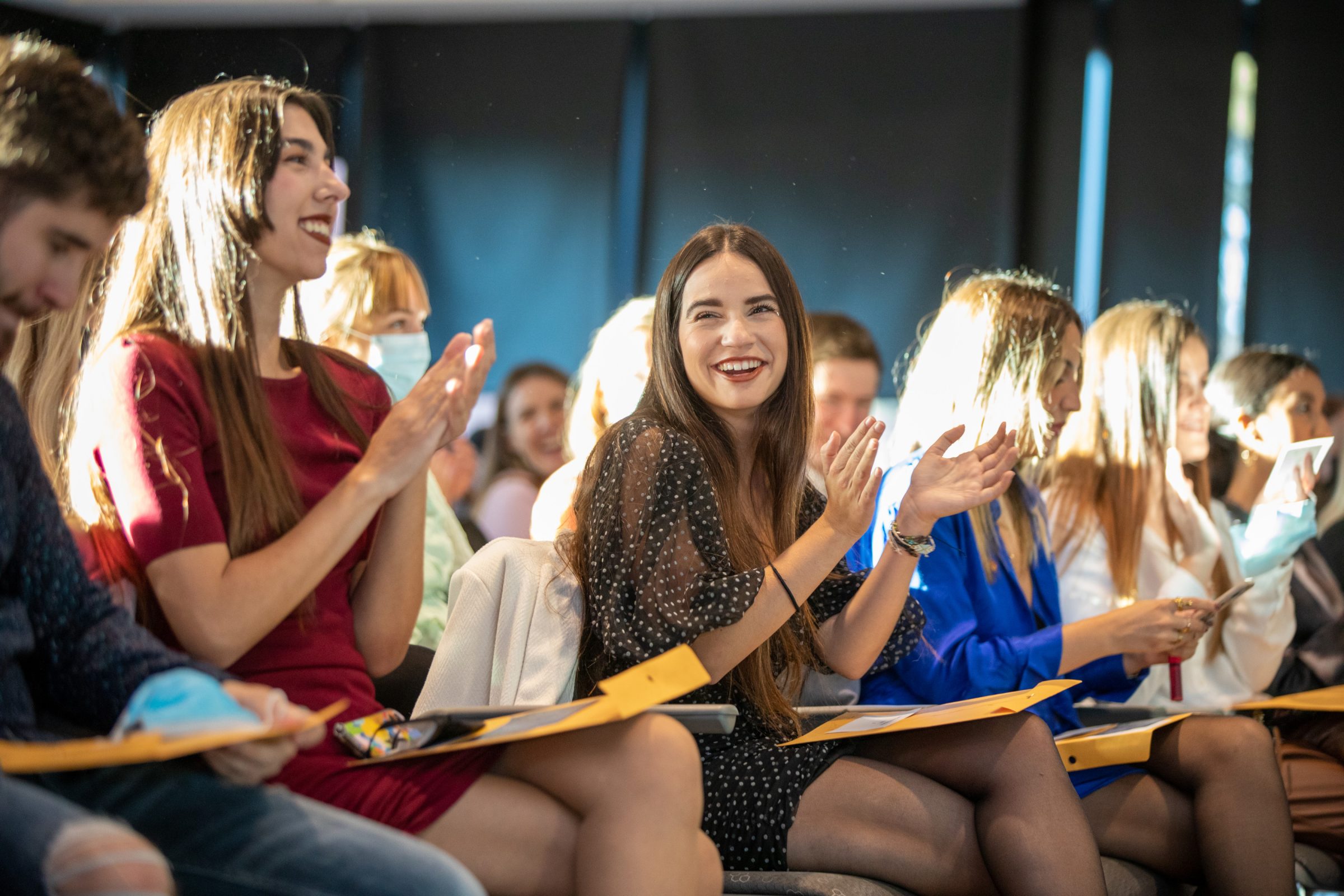 An audience of people clapping and smiling.