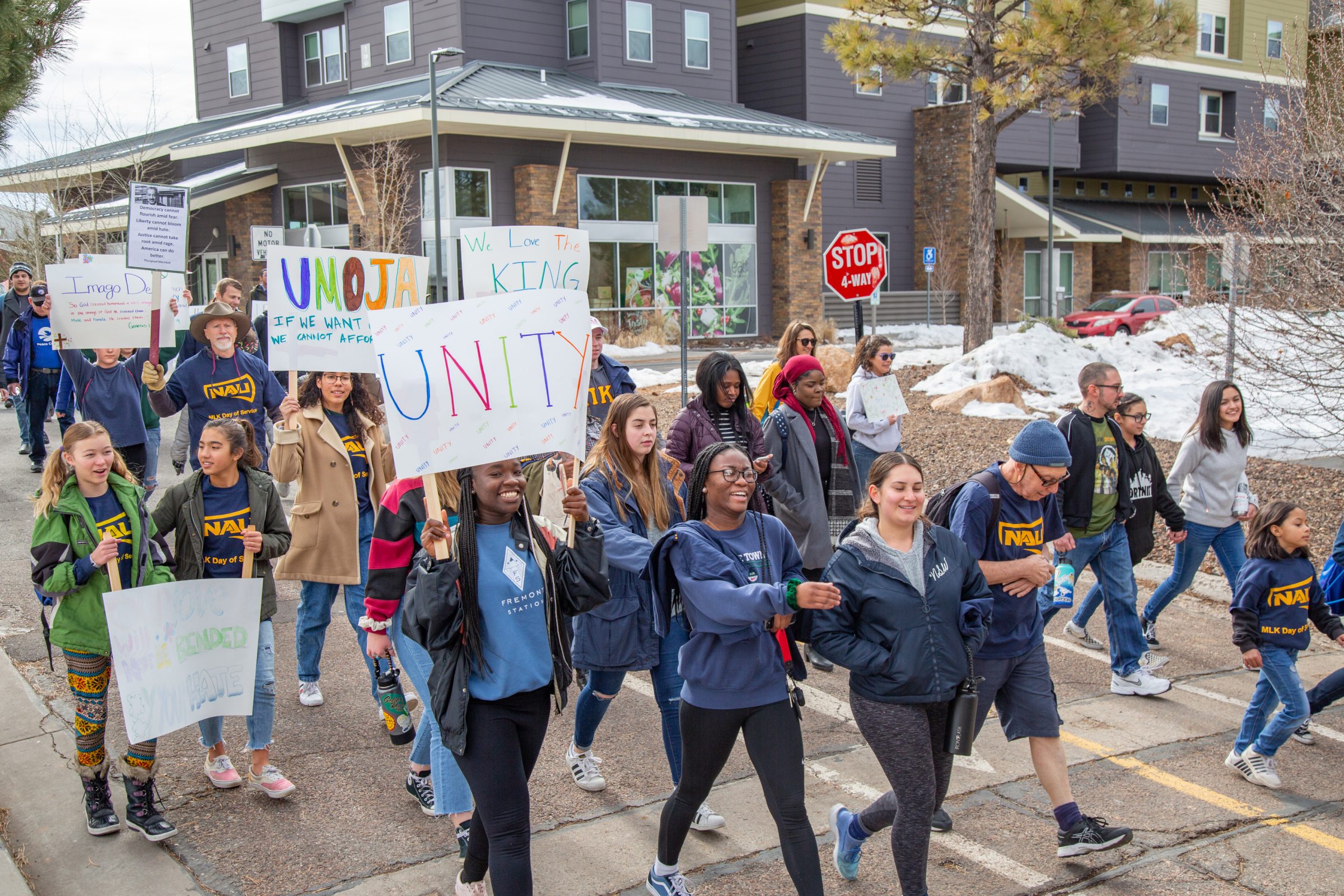 A crowd of students holding signs and marching for M L K Day.
