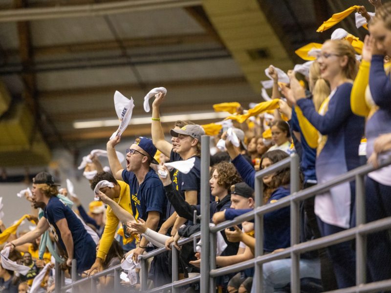 The audience of a football game at NAU Flagstaff campus cheering enthusiastically.