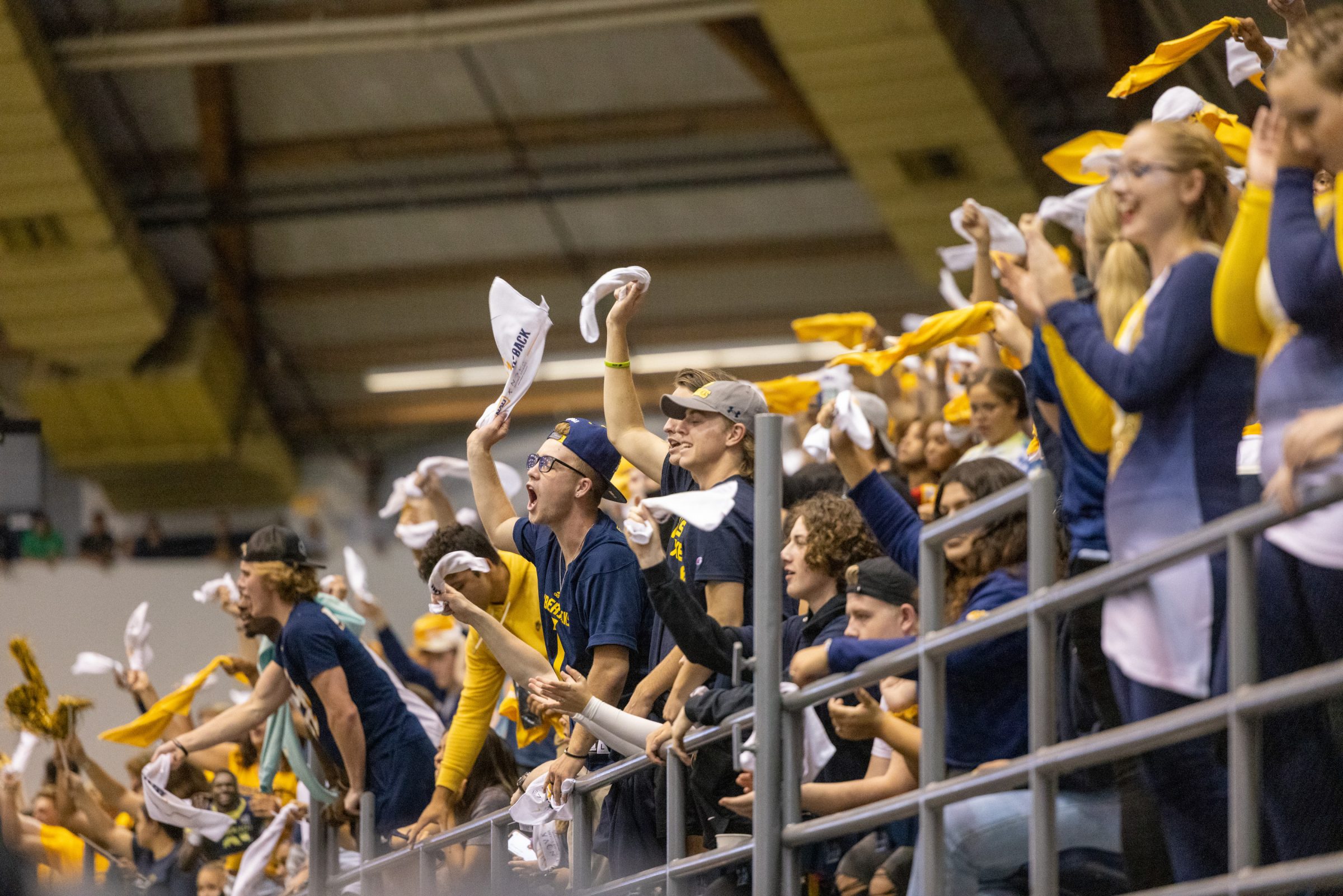 The audience of a football game at NAU Flagstaff campus cheering enthusiastically.
