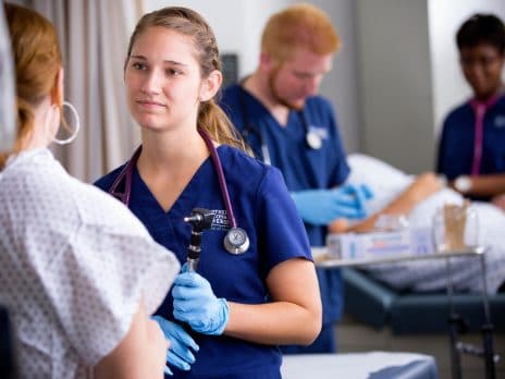 Graduate nursing student speaks with a patient.