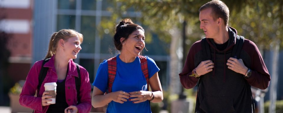 nau graduate college students walk outside on their way to class on campus