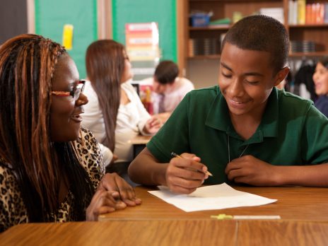 young student being taught by teacher in elementary school