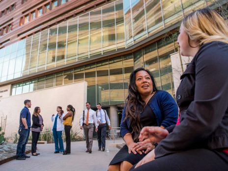 NAU DPT students discussing coursework sitting outside with the building in the background