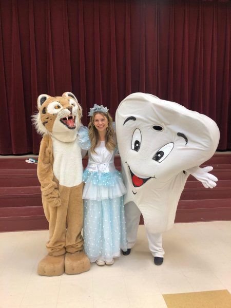 A women dressed in princess costume and with two mascot characters.