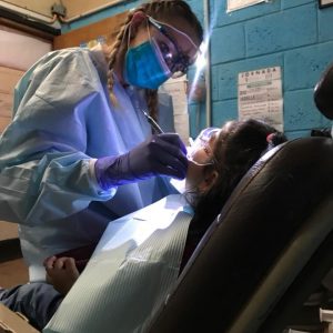 A dental hygienist working on a patient.