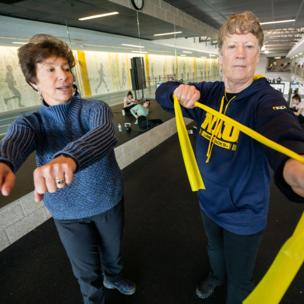An instructor demonstrates an exercise for a participant