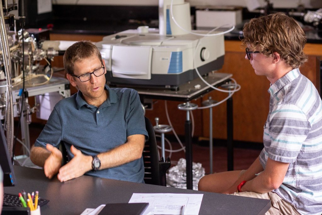 Mark Loeffler and Beau Prince talking in lab.