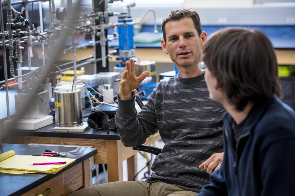 Regents’ Professor Ted Schuur in lab talking with a student.