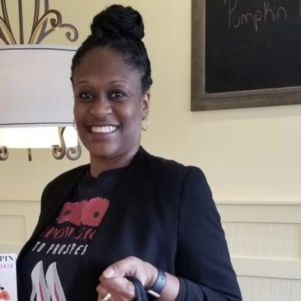 Theresa Bell holding a tote bag made by her company.