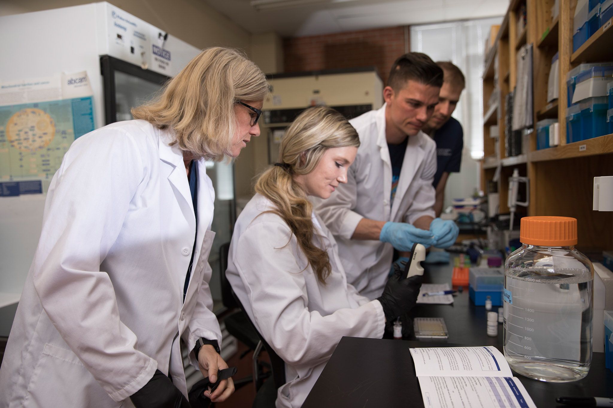 Professor Traustadóttir and students working in lab.