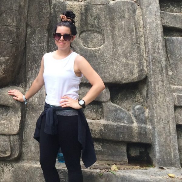 Tia Watkins standing by Mayan ruin in Belize.